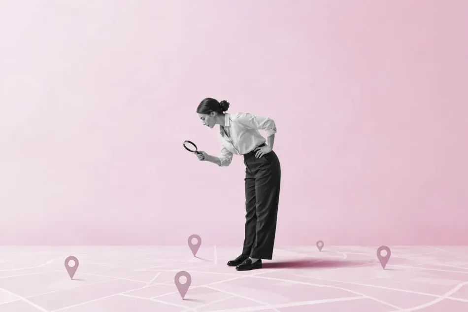 A woman examining a map dotted with location pins through a magnifying glass